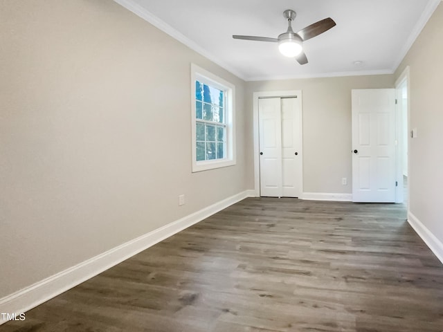 unfurnished bedroom featuring ornamental molding, dark wood-type flooring, ceiling fan, and a closet