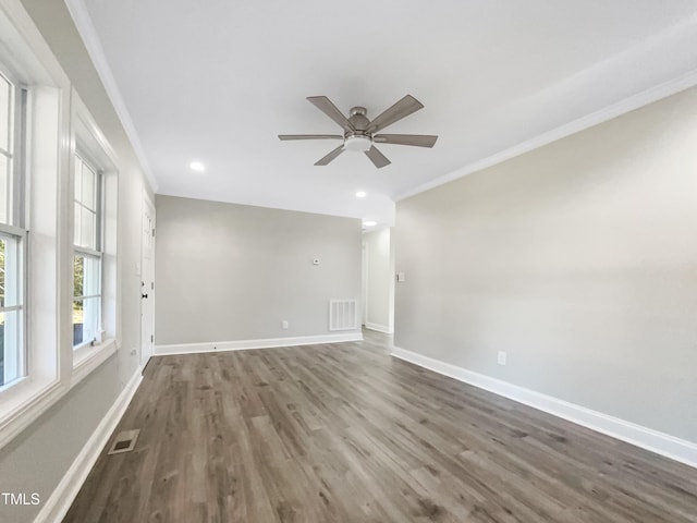 empty room featuring crown molding, dark hardwood / wood-style floors, and ceiling fan