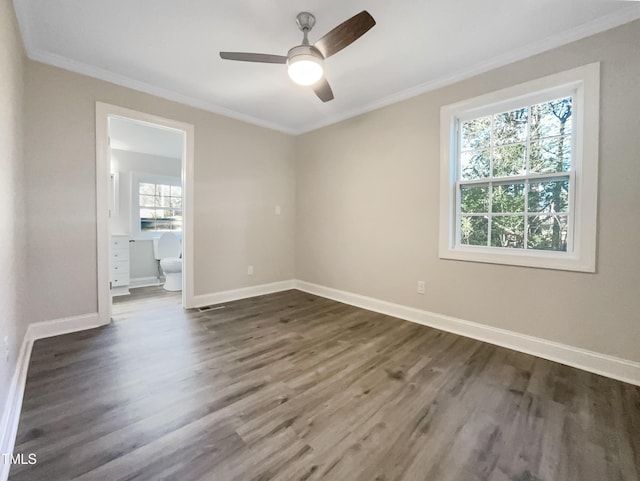 empty room featuring crown molding, dark wood-type flooring, and ceiling fan