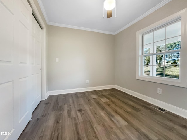 unfurnished bedroom featuring dark hardwood / wood-style flooring, ornamental molding, a closet, and ceiling fan