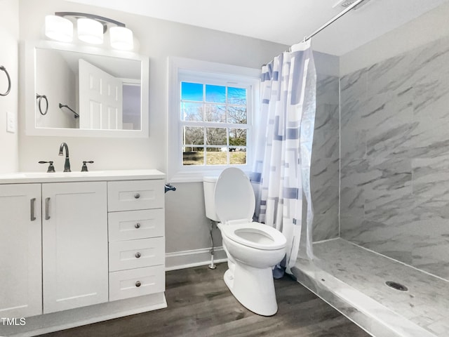 bathroom featuring vanity, curtained shower, wood-type flooring, and toilet