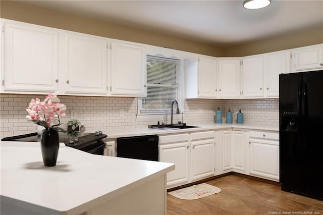 kitchen with tasteful backsplash, white cabinetry, sink, and black appliances