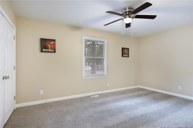 carpeted spare room featuring ceiling fan