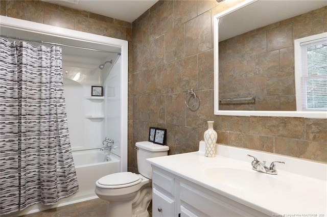 full bathroom featuring shower / tub combo with curtain, tile walls, vanity, tile patterned floors, and toilet