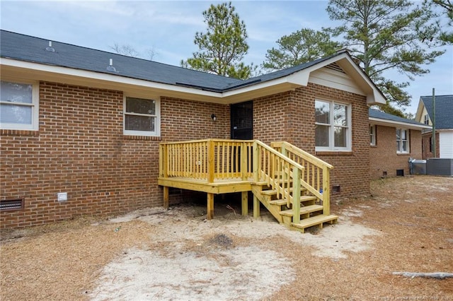 rear view of property featuring cooling unit and a deck