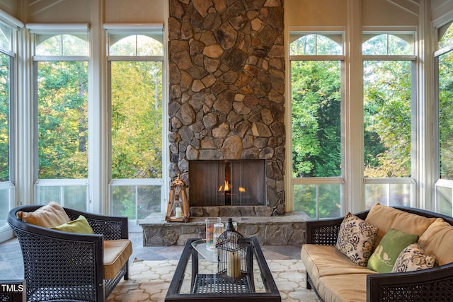 sunroom / solarium featuring a stone fireplace