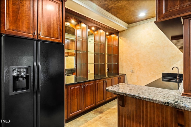 kitchen with crown molding, black refrigerator with ice dispenser, and light stone counters