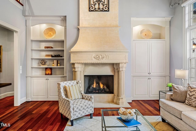 living room with dark wood-type flooring and a fireplace