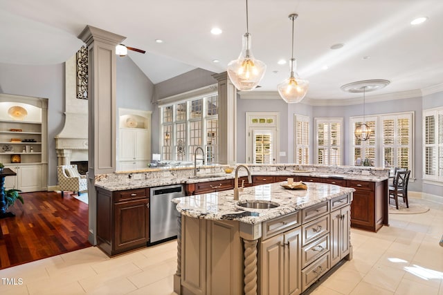 kitchen with pendant lighting, sink, stainless steel dishwasher, and an island with sink