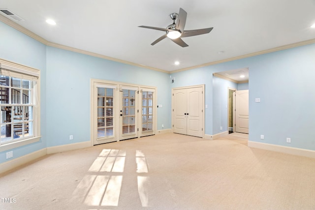 carpeted empty room with crown molding, ceiling fan, and french doors