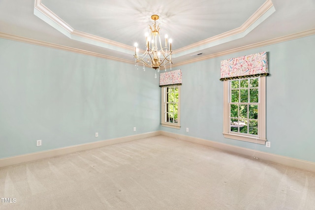 spare room featuring ornamental molding, a tray ceiling, carpet floors, and a wealth of natural light