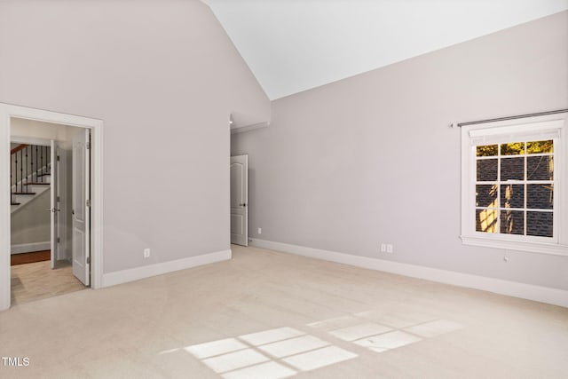 unfurnished bedroom featuring light carpet and high vaulted ceiling