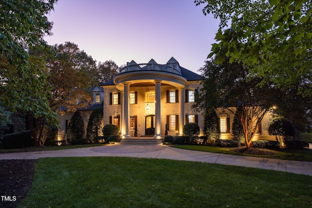 neoclassical home featuring a lawn