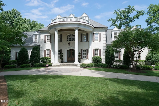 greek revival house featuring a front lawn and french doors