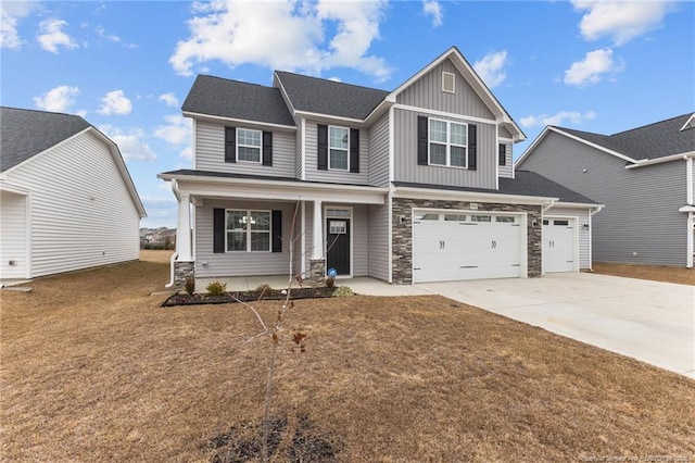 craftsman-style home featuring a porch, a garage, and a front yard