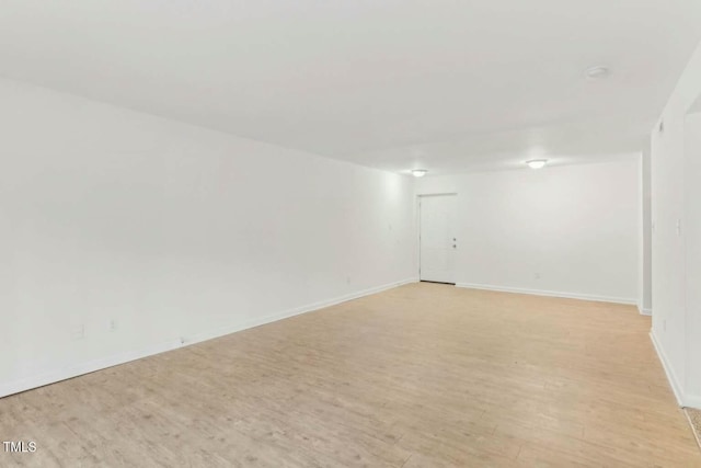 empty room featuring baseboards and light wood finished floors