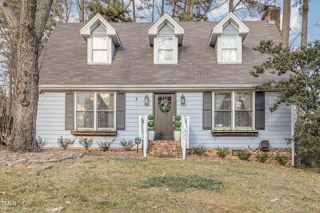 cape cod house featuring a front yard