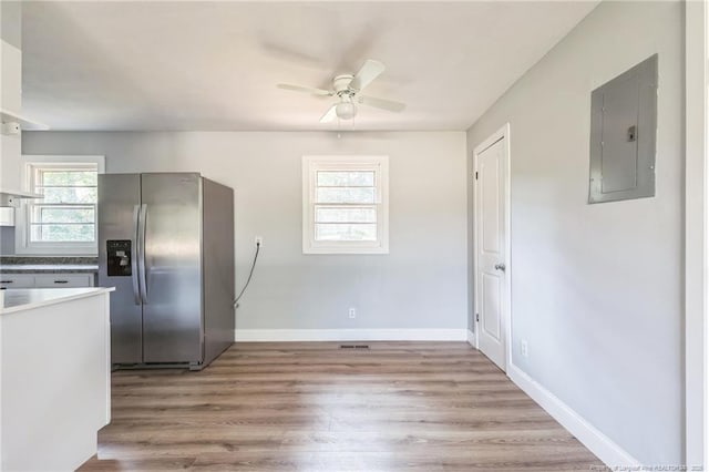 kitchen with light hardwood / wood-style floors, stainless steel fridge, ceiling fan, and electric panel