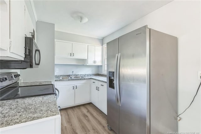 kitchen featuring sink, light hardwood / wood-style flooring, stainless steel appliances, and white cabinets