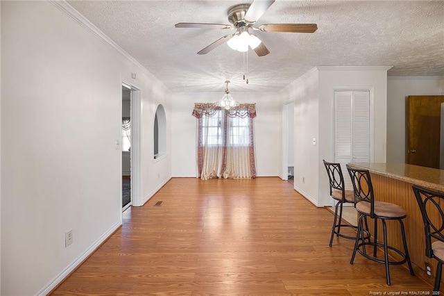 dining area featuring ornamental molding, hardwood / wood-style floors, and a textured ceiling