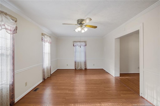 spare room with crown molding, a textured ceiling, wood-type flooring, and ceiling fan