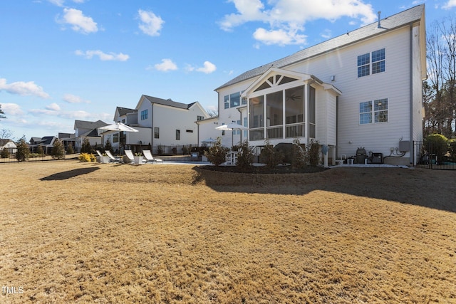 back of property featuring a residential view, a sunroom, and fence