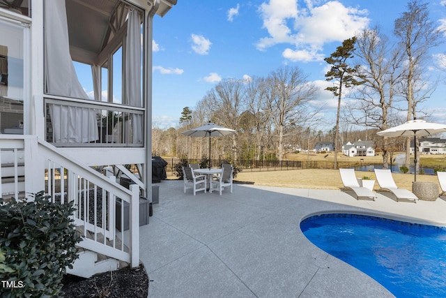 view of pool featuring a fenced in pool, a sunroom, fence, outdoor dining area, and a patio area