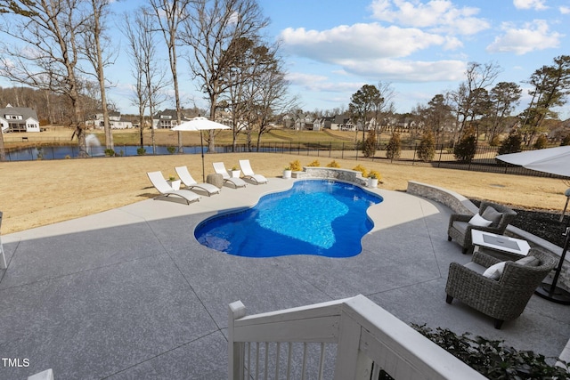 view of pool with a water view, a patio area, a fenced backyard, and a yard