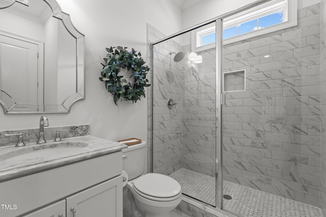 full bathroom featuring a stall shower, vanity, and toilet