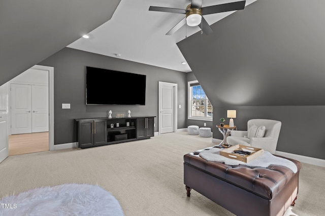 carpeted living area with lofted ceiling, ceiling fan, and baseboards