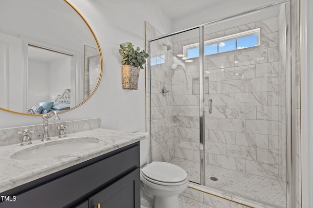 bathroom featuring toilet, a shower stall, and vanity