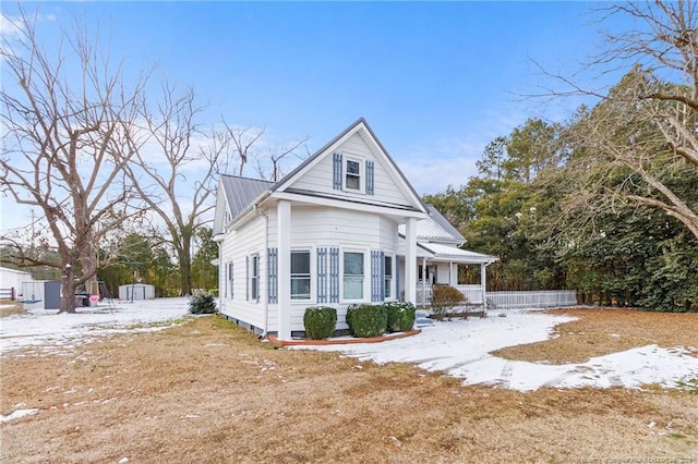 view of front of home with a storage unit and covered porch