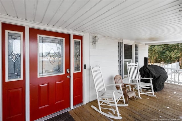 view of exterior entry featuring covered porch