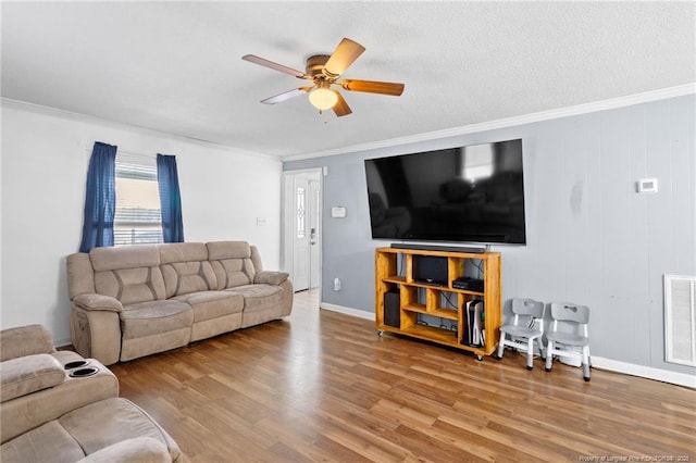 living room with crown molding, ceiling fan, a textured ceiling, and hardwood / wood-style flooring