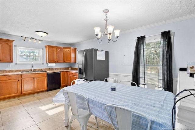 tiled dining space with ornamental molding, sink, a chandelier, and a textured ceiling