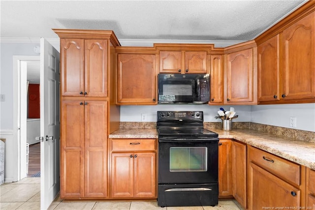 kitchen featuring crown molding, light tile patterned floors, a textured ceiling, and black appliances