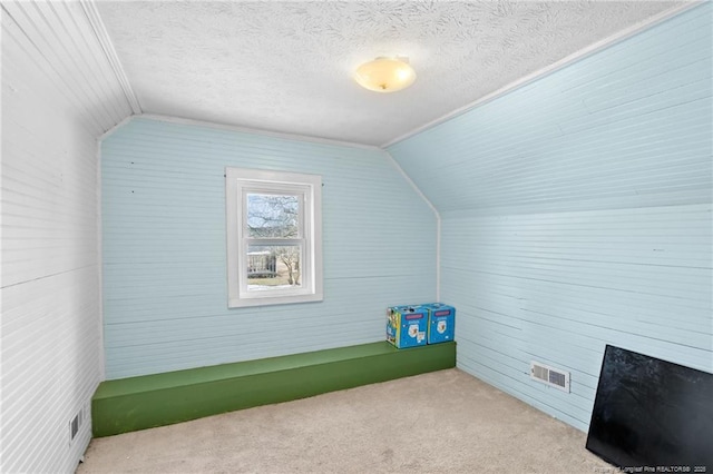 bonus room with lofted ceiling, light carpet, and a textured ceiling