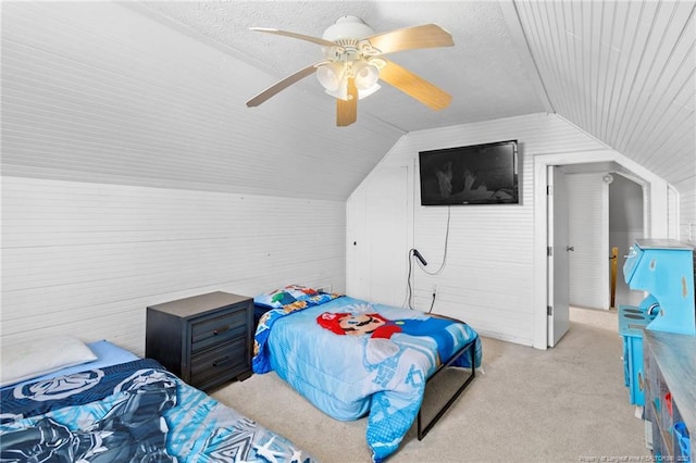 bedroom featuring lofted ceiling, light colored carpet, a textured ceiling, and ceiling fan