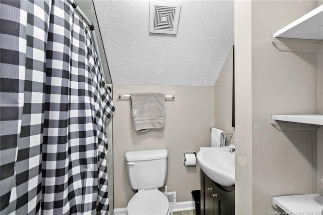 bathroom featuring lofted ceiling, toilet, vanity, and a textured ceiling