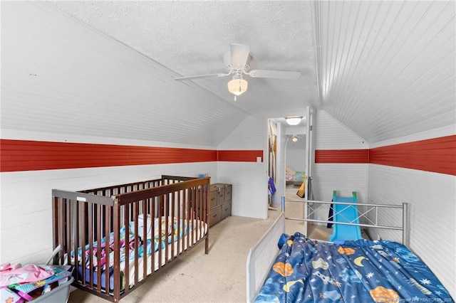 bedroom with vaulted ceiling, a textured ceiling, and ceiling fan