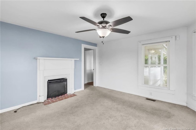 unfurnished living room featuring visible vents, carpet, ceiling fan, and a fireplace