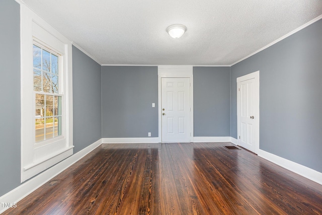 unfurnished room featuring dark wood-style floors, crown molding, a textured ceiling, and baseboards