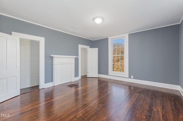 unfurnished bedroom featuring dark wood-type flooring, crown molding, a textured ceiling, and baseboards