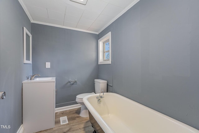 bathroom with toilet, wood-type flooring, ornamental molding, vanity, and a washtub