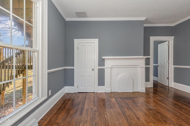 interior space featuring a textured ceiling, visible vents, dark wood-type flooring, and ornamental molding