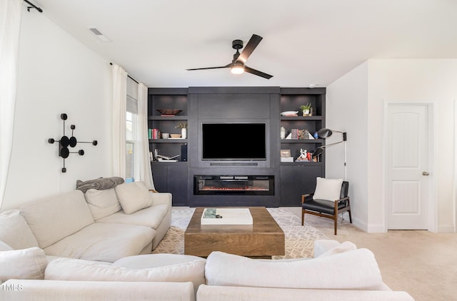 living room with a large fireplace, light carpet, and ceiling fan