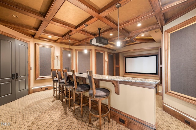 carpeted cinema with coffered ceiling and beam ceiling