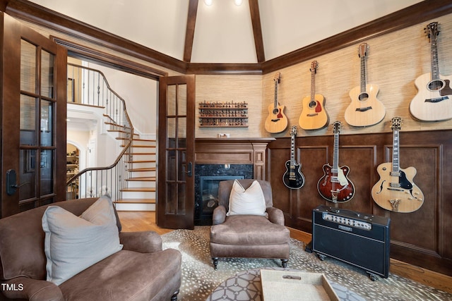 living area with beam ceiling, wood walls, high vaulted ceiling, a premium fireplace, and hardwood / wood-style floors