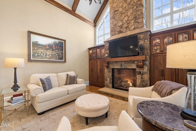 living room featuring beam ceiling, a stone fireplace, high vaulted ceiling, and hardwood / wood-style flooring