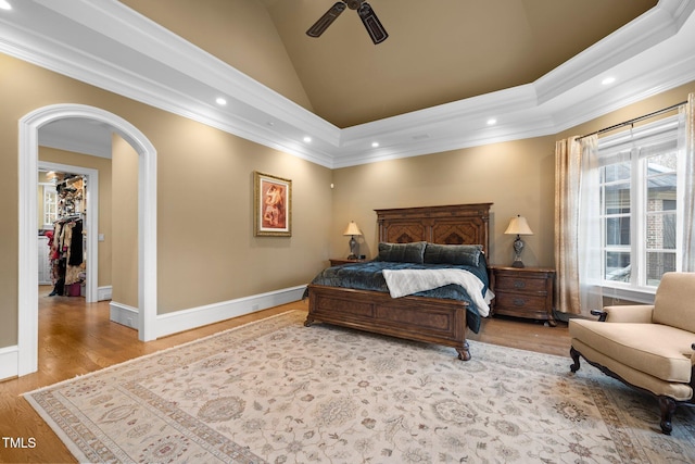 bedroom with ceiling fan, ornamental molding, light hardwood / wood-style floors, a spacious closet, and a closet